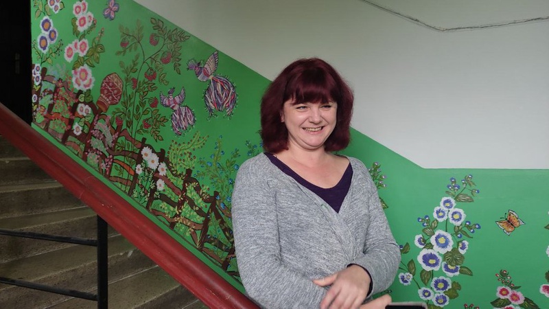 Лучанка розмальовує під’їзд у петриківському стилі